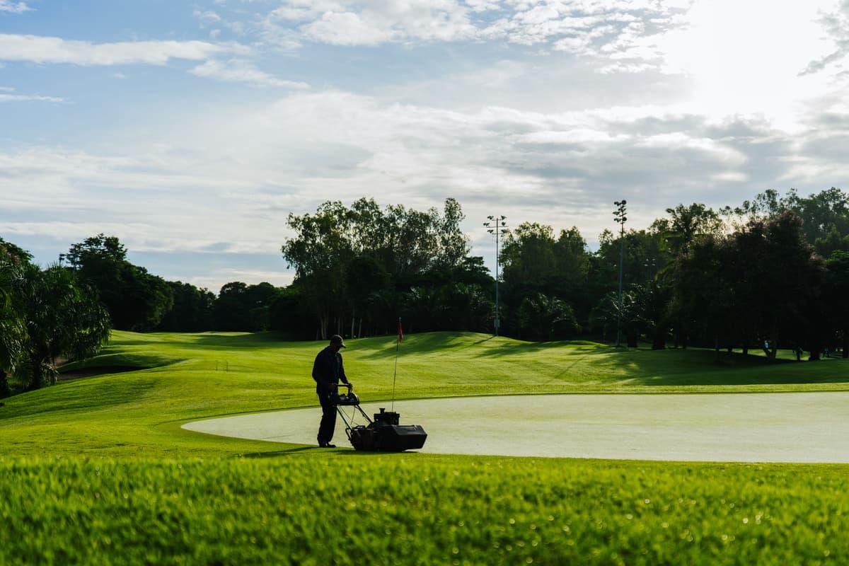 A groundskeeper maintaining a large commercial green space
